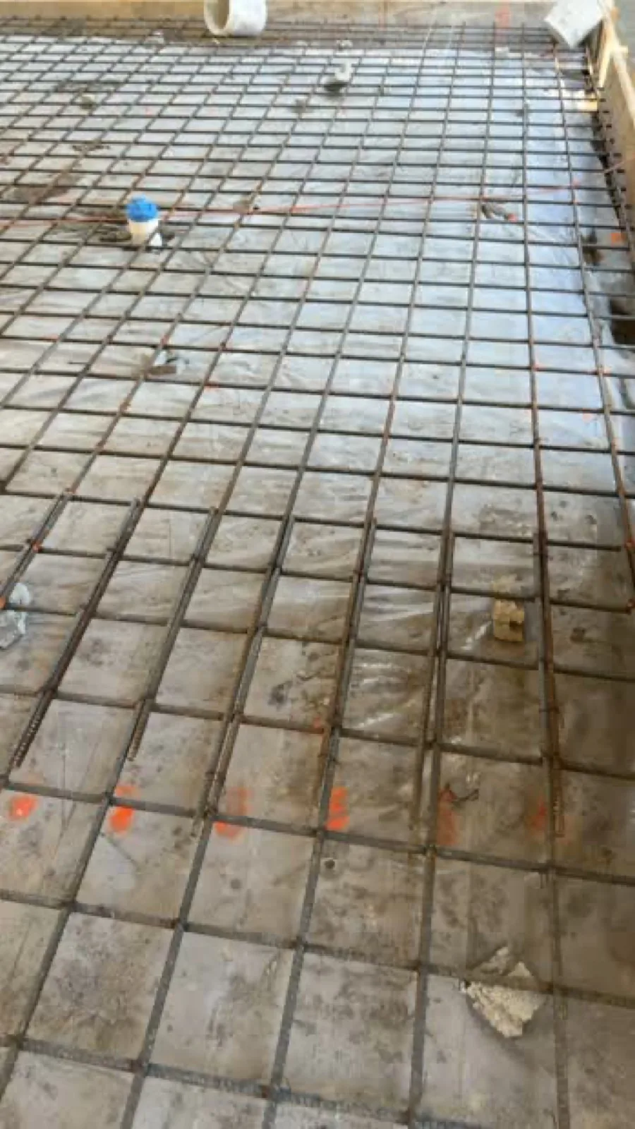 Closely spaced reinforcing steel and marked penetrations prepared before a concrete placement.