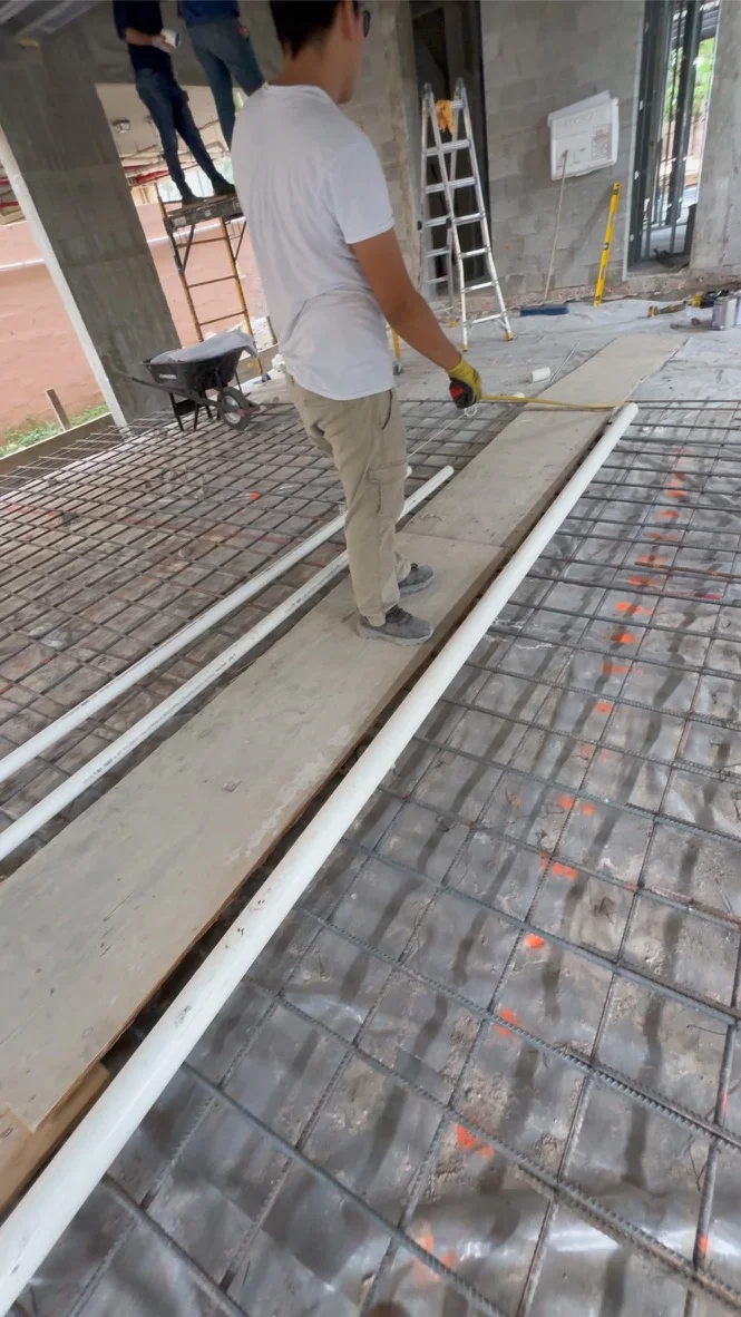 Reinforcing grid and embedded service conduits documented before concrete placement at Leslie House.